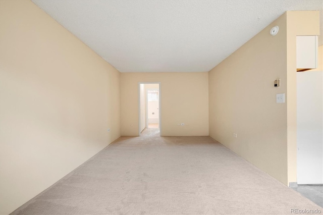 empty room featuring light colored carpet and a textured ceiling
