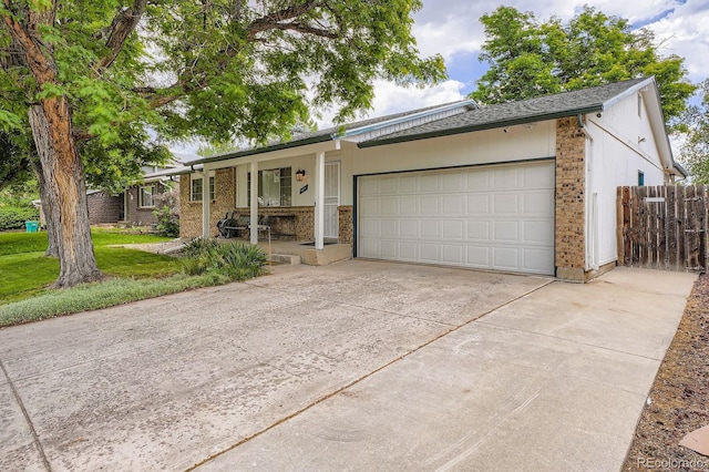 6314 S Johnson St, Littleton, CO 80123 - ranch-style house featuring concrete driveway, brick siding, a garage, and covered porch