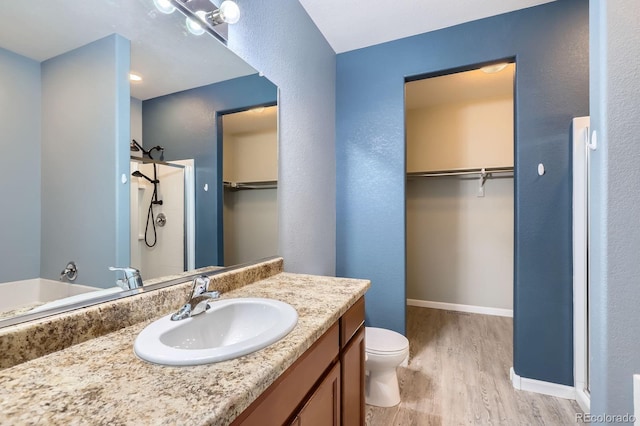449 Vista Blvd, Lochbuie, CO 80603 - bathroom featuring wood finished floors, vanity, a spacious closet, and a shower