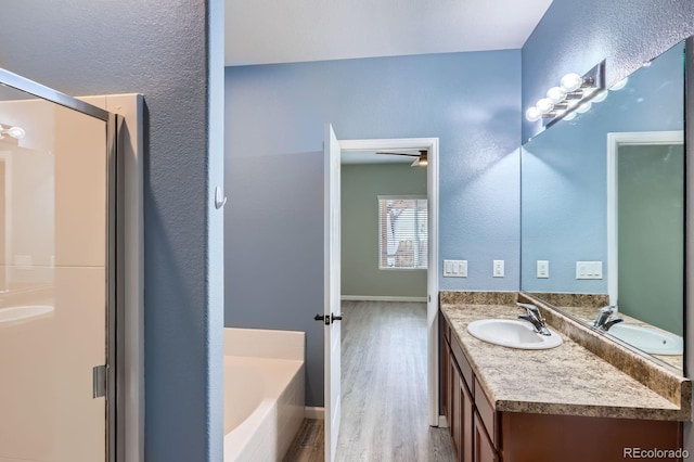 449 Vista Blvd, Lochbuie, CO 80603 - full bathroom featuring vanity, wood finished floors, a stall shower, a bath, and a textured wall
