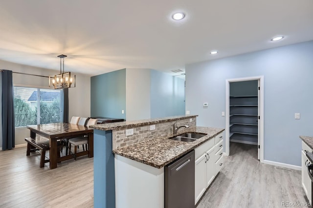 449 Vista Blvd, Lochbuie, CO 80603 - kitchen with stainless steel dishwasher, light wood-type flooring, dark stone counters, white cabinetry, and a center island with sink
