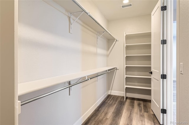 walk in closet with dark hardwood / wood-style floors