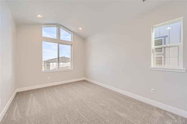 empty room featuring carpet and vaulted ceiling