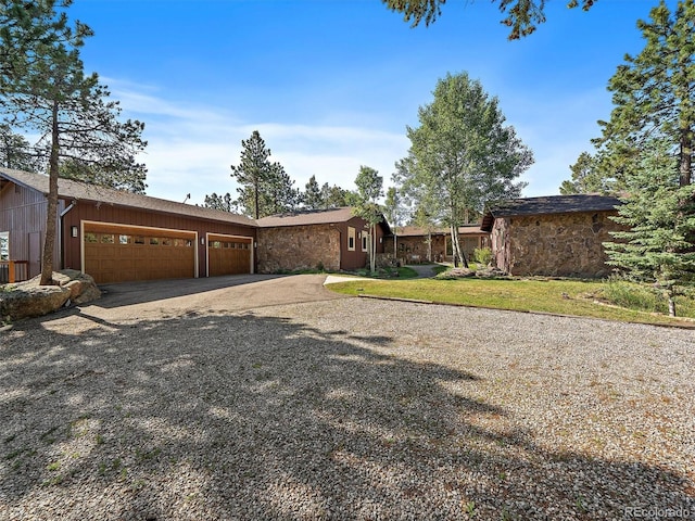 28550 Cavan Ln, Evergreen, CO 80439 - view of front of house featuring concrete driveway, stone siding, a garage, and a front yard