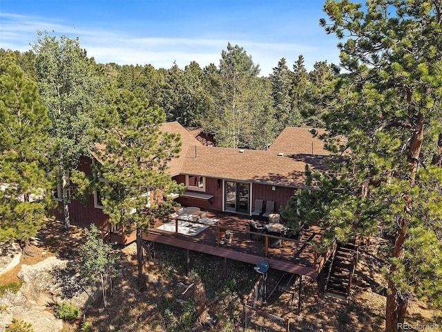 28550 Cavan Ln, Evergreen, CO 80439 - rear view of property featuring roof with shingles, a wooden deck, and a forest view