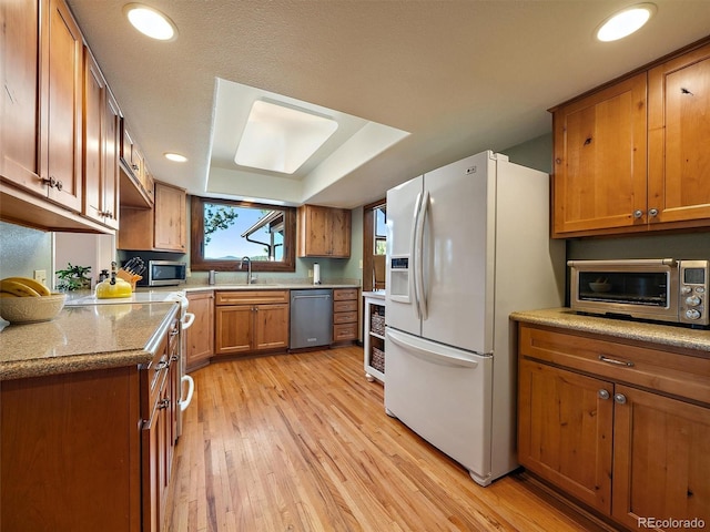28550 Cavan Ln, Evergreen, CO 80439 - kitchen with stainless steel appliances, light wood-type flooring, brown cabinets, recessed lighting, and light stone counters