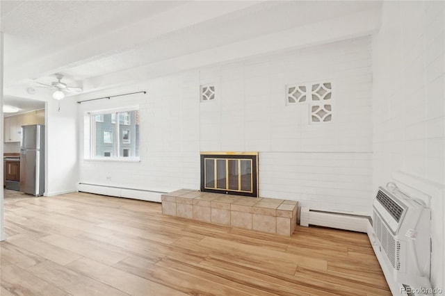 unfurnished living room featuring baseboard heating, a tiled fireplace, light wood-style flooring, ceiling fan, and a baseboard heating unit