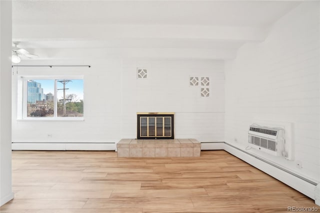 unfurnished living room featuring a baseboard heating unit, a fireplace, light wood finished floors, and a wall unit AC