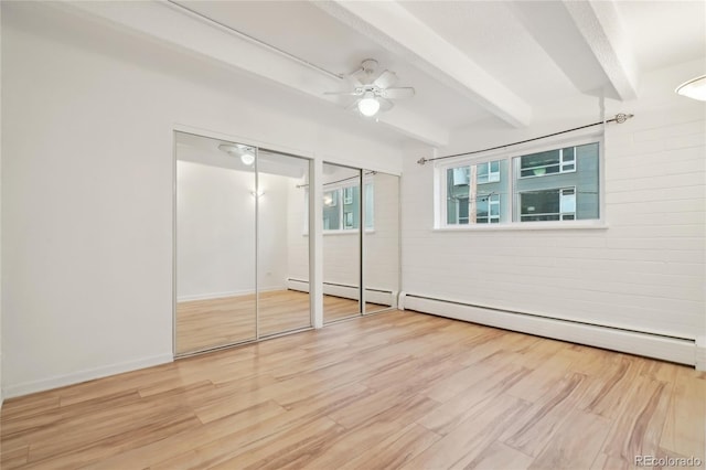 unfurnished bedroom featuring multiple closets, beam ceiling, wood finished floors, ceiling fan, and baseboards