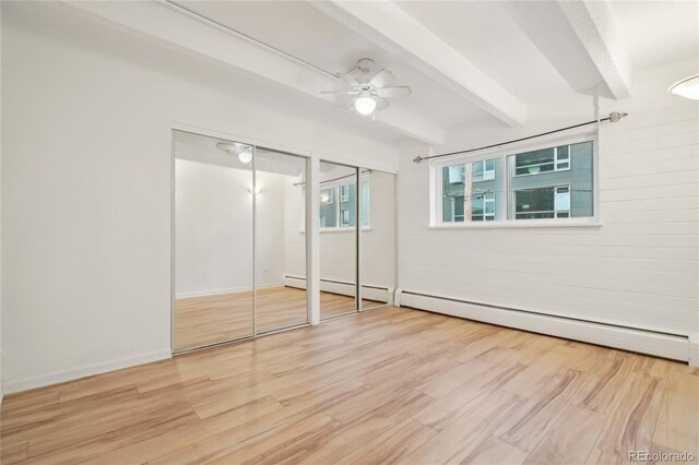 250 N Pearl St Unit 310, Denver, CO 80203 - unfurnished bedroom with multiple closets, beam ceiling, wood finished floors, a ceiling fan, and a baseboard radiator