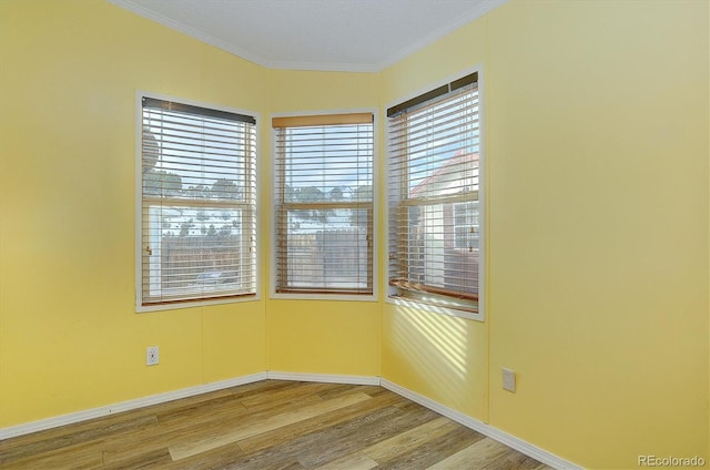 unfurnished room with hardwood / wood-style flooring and ornamental molding