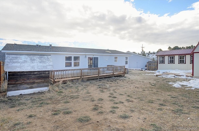 back of property with a wooden deck and an outbuilding