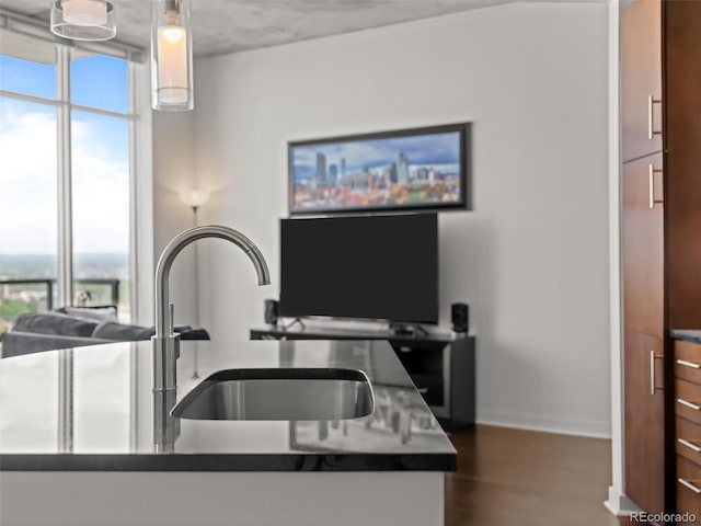 891 14th St Unit 3411, Denver, CO 80202 - kitchen featuring a sink, dark wood finished floors, baseboards, floor to ceiling windows, and dark countertops