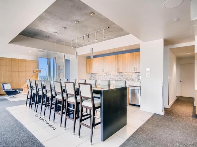 891 14th St Unit 3411, Denver, CO 80202 - kitchen with stainless steel dishwasher, light tile patterned floors, track lighting, tasteful backsplash, and light brown cabinetry