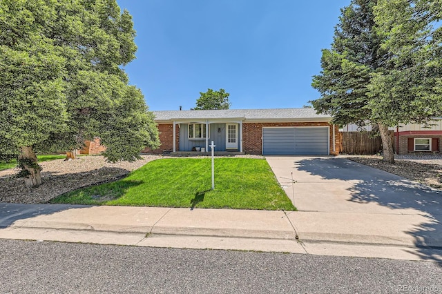 912 S Kingston St, Aurora, CO 80012 - view of front facade with brick siding, an attached garage, and driveway