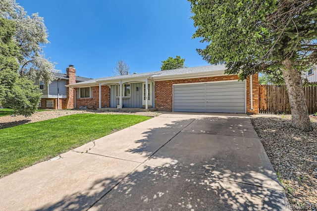 912 S Kingston St, Aurora, CO 80012 - view of front of house featuring brick siding, a garage, concrete driveway, a porch, and a chimney