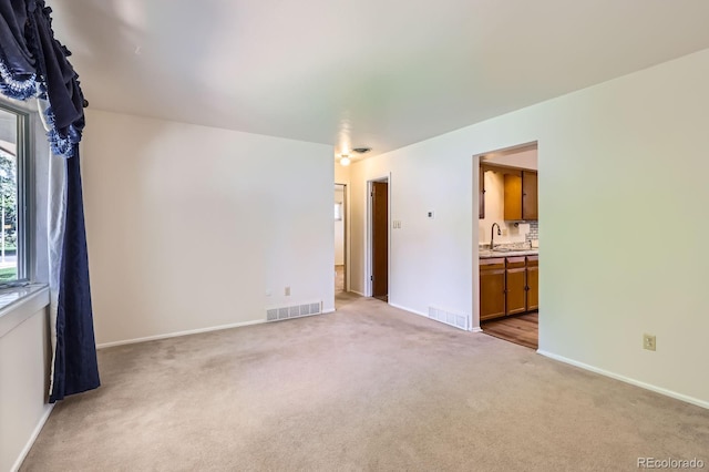 912 S Kingston St, Aurora, CO 80012 - unfurnished room featuring light colored carpet, baseboards, and a sink