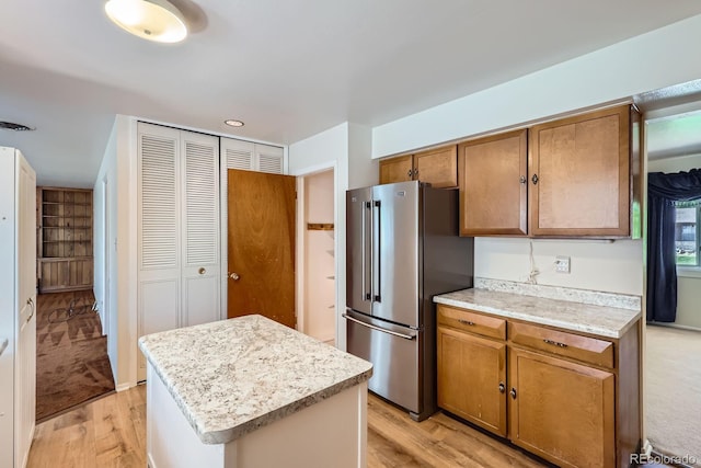 912 S Kingston St, Aurora, CO 80012 - kitchen with freestanding refrigerator, light wood finished floors, light countertops, and brown cabinets