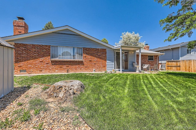 912 S Kingston St, Aurora, CO 80012 - rear view of house featuring brick siding and a chimney