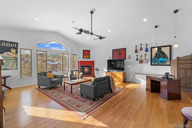 living room featuring light wood-type flooring, ceiling fan, and vaulted ceiling