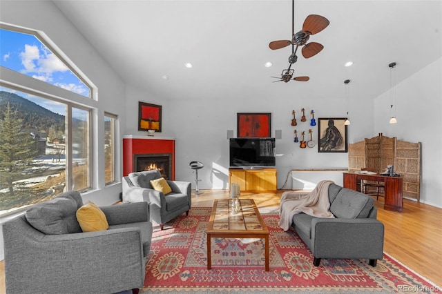 living room featuring ceiling fan, hardwood / wood-style floors, and a wealth of natural light