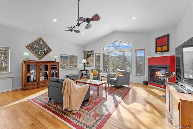 living room with lofted ceiling, light wood-type flooring, and ceiling fan