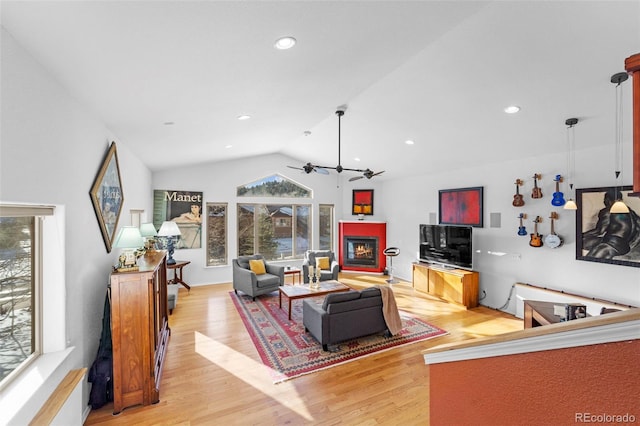 living room featuring light hardwood / wood-style floors, ceiling fan, and vaulted ceiling