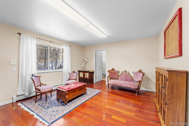 sitting room with hardwood / wood-style floors and a baseboard radiator