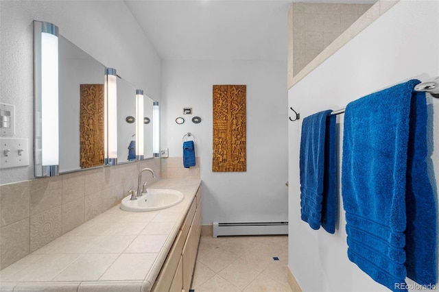 bathroom with vanity, a baseboard radiator, tile patterned flooring, and backsplash