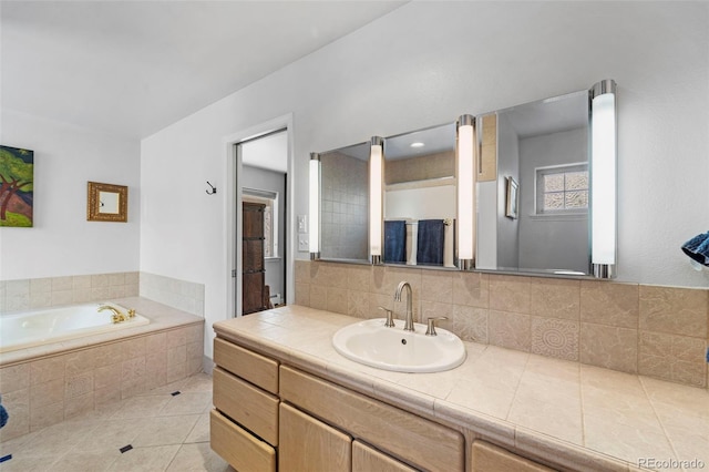 bathroom featuring vanity, tile patterned flooring, and tiled bath