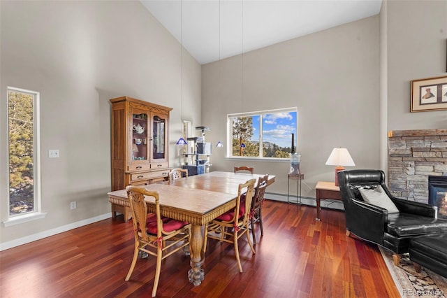 dining area featuring high vaulted ceiling, a baseboard radiator, a fireplace, and dark wood-type flooring