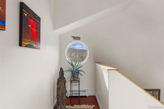 staircase with lofted ceiling, wood-type flooring, and a baseboard radiator