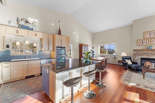 kitchen featuring a kitchen island, a kitchen bar, decorative backsplash, and sink