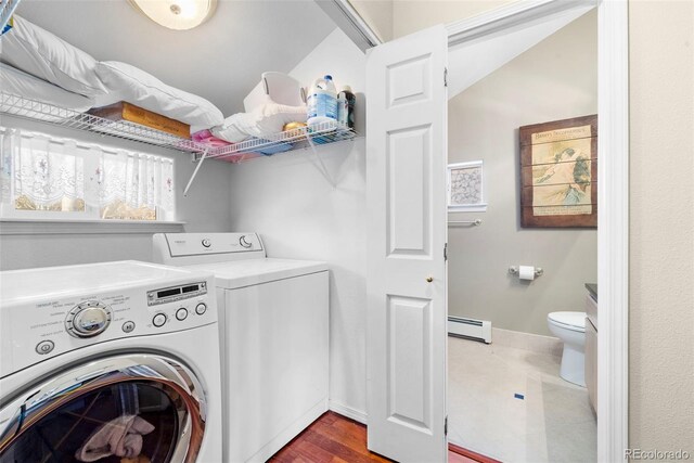 washroom with a baseboard heating unit and washing machine and dryer