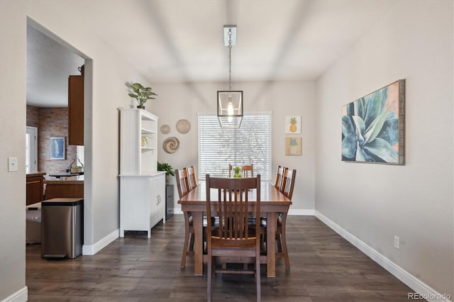 dining room with baseboards and dark wood finished floors