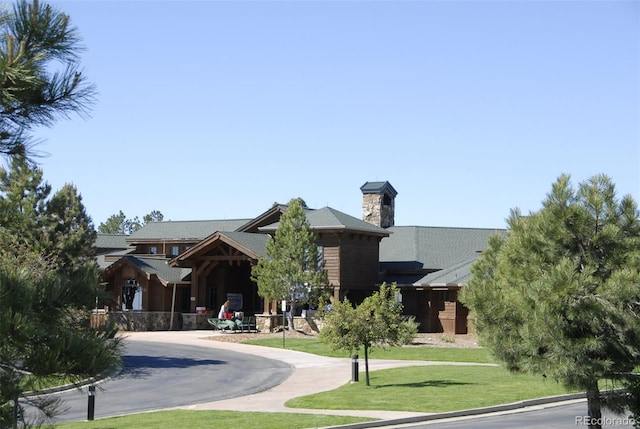 8114 Briar Ridge Dr, Castle Pines, CO 80108 - view of front of house with a front lawn, a chimney, and curved driveway