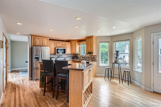 5784 W 81st Cir, Arvada, CO 80003 - kitchen with appliances with stainless steel finishes, a kitchen bar, recessed lighting, light wood-type flooring, and baseboards