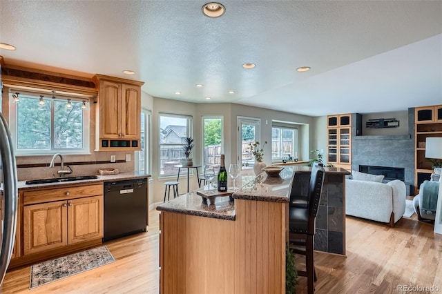 5784 W 81st Cir, Arvada, CO 80003 - kitchen with dishwasher, a sink, a breakfast bar, light wood finished floors, and recessed lighting