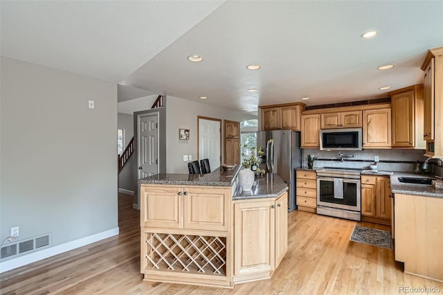 5784 W 81st Cir, Arvada, CO 80003 - kitchen with stainless steel appliances, a sink, light wood-style floors, a center island, and recessed lighting