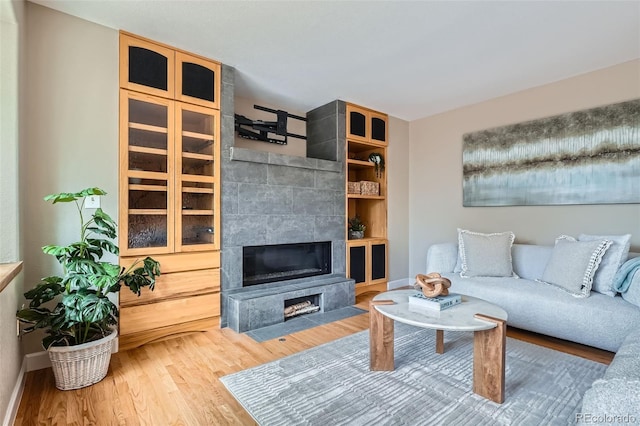 5784 W 81st Cir, Arvada, CO 80003 - living room with wood finished floors, a tiled fireplace, and baseboards