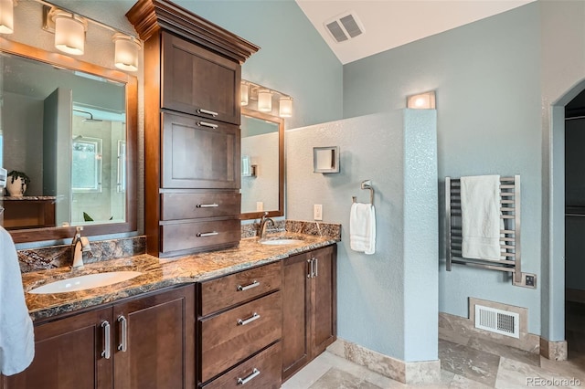5784 W 81st Cir, Arvada, CO 80003 - bathroom featuring lofted ceiling, radiator, baseboards, double vanity, and a textured wall