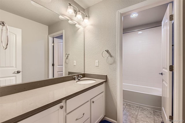 bathroom with tile patterned floors, vanity, and tiled shower / bath combo