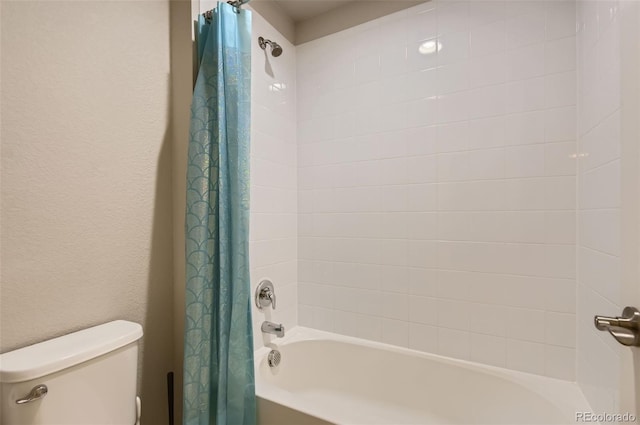 bathroom featuring shower / tub combo and toilet