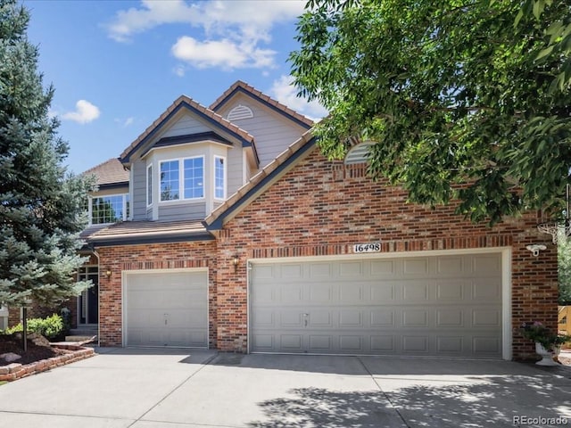 16498 E Lake Dr, Centennial, CO 80016 - traditional-style house featuring brick siding, concrete driveway, and a tiled roof