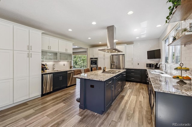 16498 E Lake Dr, Centennial, CO 80016 - kitchen featuring appliances with stainless steel finishes, island exhaust hood, white cabinetry, backsplash, and recessed lighting