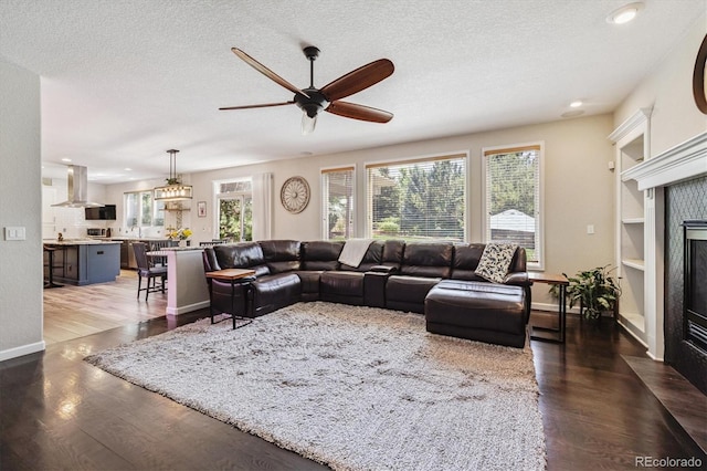 16498 E Lake Dr, Centennial, CO 80016 - living room featuring a fireplace with flush hearth, a ceiling fan, recessed lighting, a textured ceiling, and wood finished floors