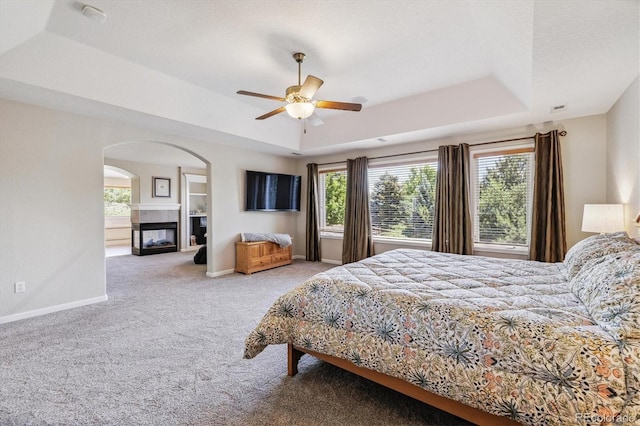 16498 E Lake Dr, Centennial, CO 80016 - bedroom featuring a raised ceiling, multiple windows, carpet floors, and arched walkways