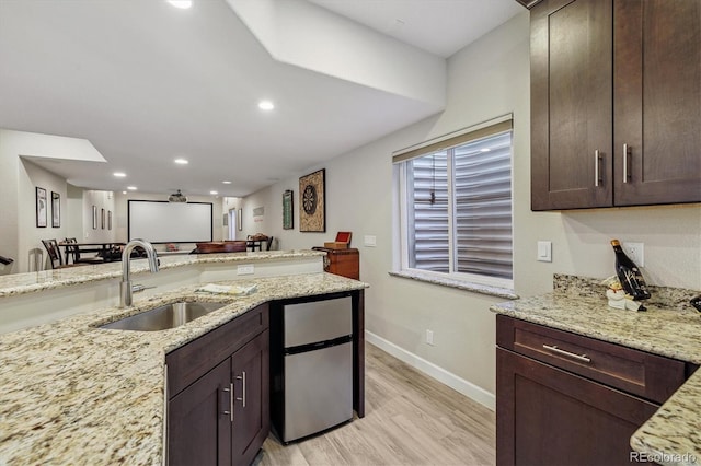 16498 E Lake Dr, Centennial, CO 80016 - kitchen with light wood-style flooring, freestanding refrigerator, dark brown cabinets, light stone countertops, and recessed lighting