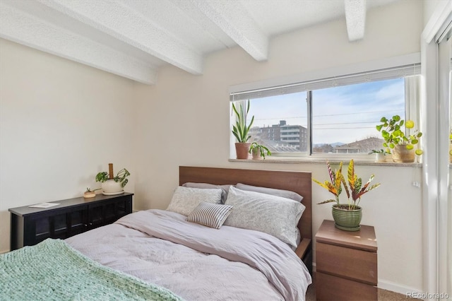 bedroom featuring beamed ceiling, a textured ceiling, and baseboards