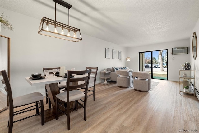 7770 W 38th Ave Unit 108, Wheat Ridge, CO 80033 - dining area featuring a textured ceiling, a wall mounted AC, baseboards, and light wood-type flooring